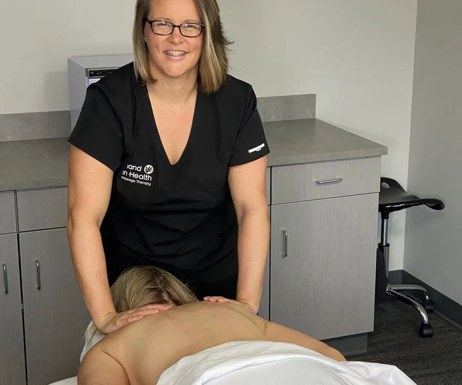 Hand in Health massage therapist working on a patient’s upper back during a massage session