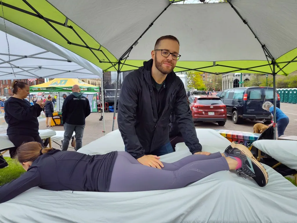 Hand in Health massage therapists treating runners under the tent at the Mountain Goat Run in Syracuse