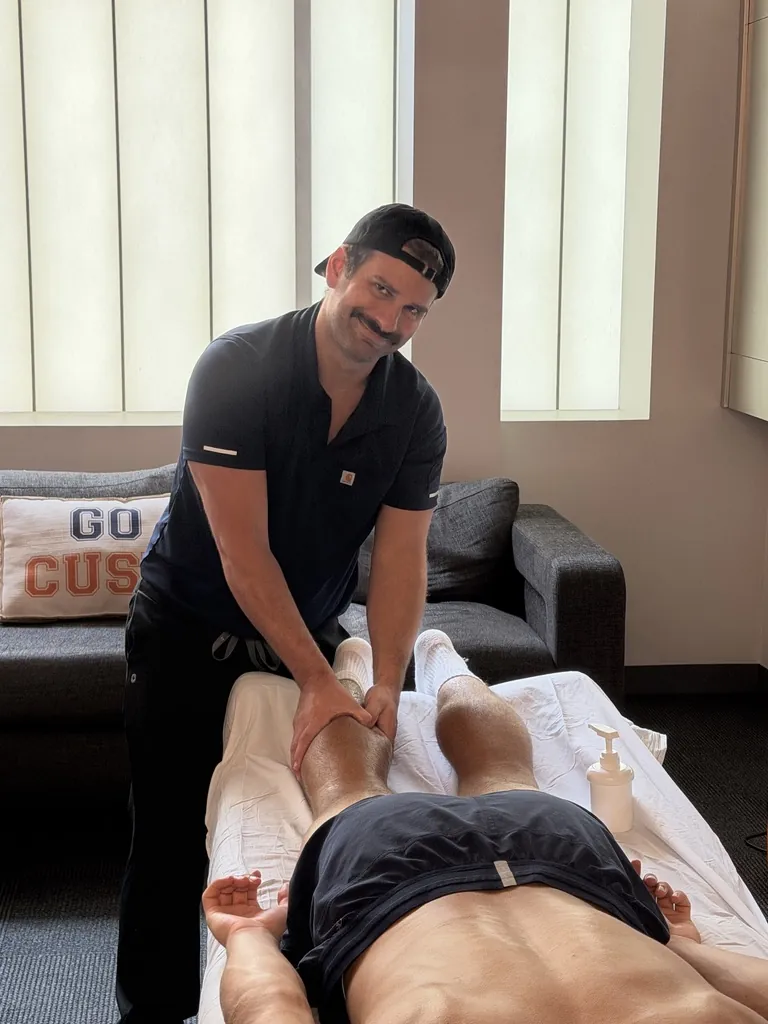 Hand in Health therapist giving sports massage to a Syracuse University athlete