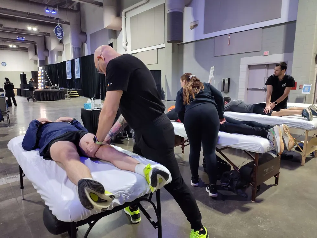 Hand in Health massage therapist working on a runner's legs after the Syracuse Half Marathon